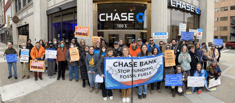 People in front of a Chase bank holding sign that reads: Chase Bank, Stop Supporting Fossil Fuels