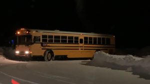 A yellow school bus on a dark road