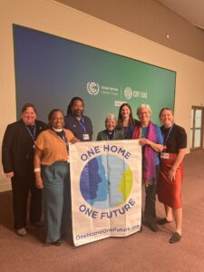 Group of Faith Leaders Holding One Home One Future Banner at COP28