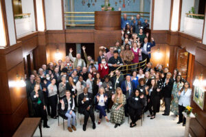 Large Group of Faith and Climate Leaders waving from floor and stairway below